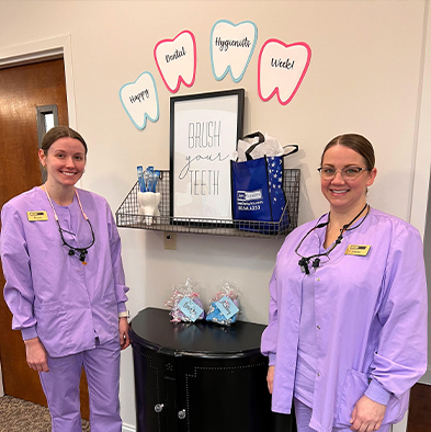 Two Fort Mill dental team members in light purple scrubs