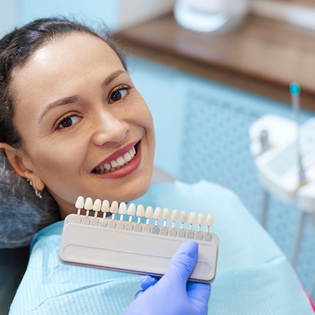 Woman preparing for veneers and dentist holding a shade guide