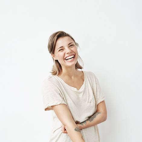 Laughing woman standing against neutral background
