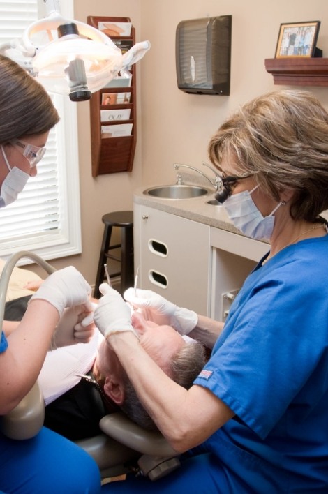 Two dentists examining a patient's mouth