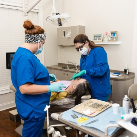 Two dentists providing emergency dental care to a patient