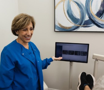 Fort Mill dentist gesturing to computer screen with patient