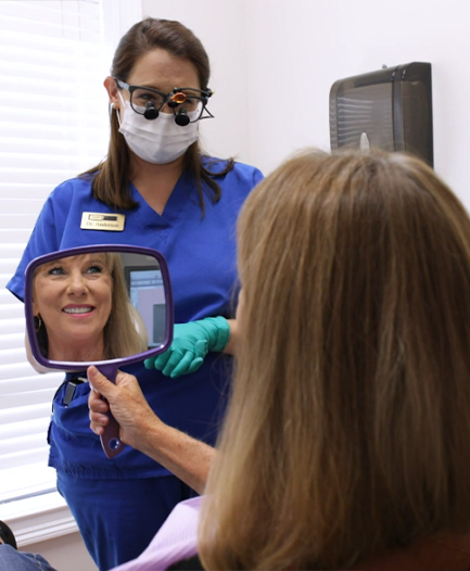 Dental patient seeing her smile in a mirror