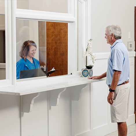 Man talking to dental team member at front desk