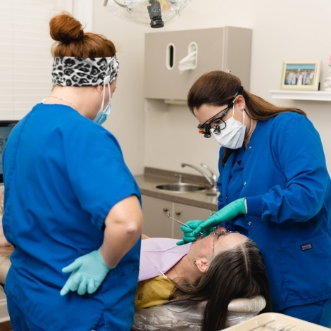 Dental team member giving a dental patient a teeth cleaning