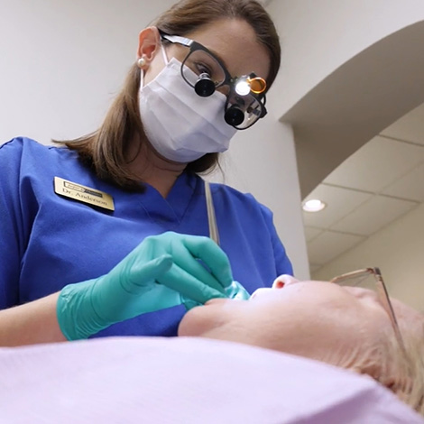 Dentist performing oral cancer screening on a dental patient