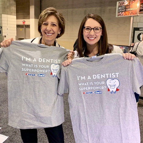 Fort Mill dentists holding T shirts that say I am a dentist what is your superpower