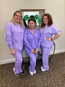Three Fort Mill dental team members in light purple scrubs