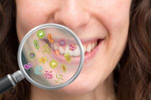 : Magnifying glass showing representation of bacteria in human mouth