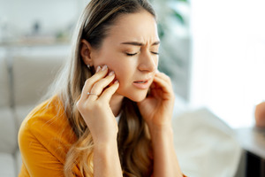 Close-up of young woman with jaw pain