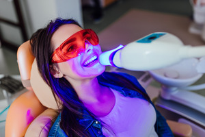 Female patient during professional teeth whitening treatment